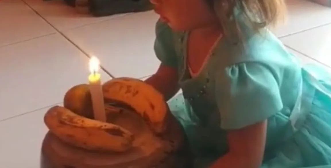 Con una olla, dos plátanos y una vela una pequeña festeja su cumpleaños
