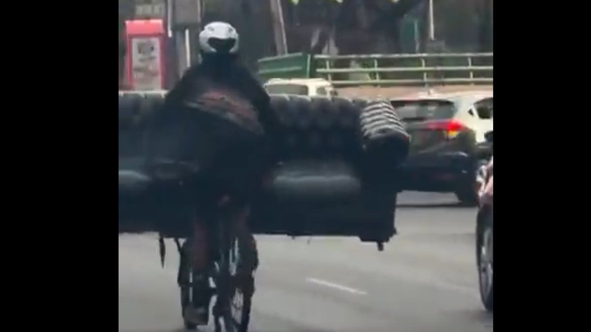 ¡Con todo y sillón! Ciclista sorprende al transportar mueble en plena vía rápida